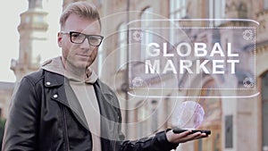 Smart young man with glasses shows a conceptual hologram Global market