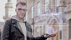 Smart young man with glasses shows a conceptual hologram small business jet aircraft