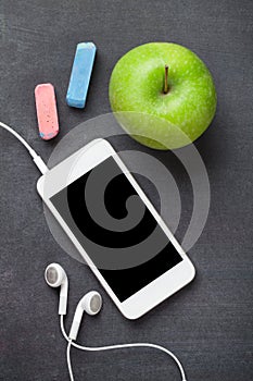 Smartphone and apple on blackboard background