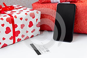 Smartphone with a bank card and Christmas gifts on the table. Online shopping festive internet concept