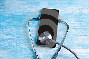 Smartphone being diagnosed by stethoscope - phone repair and check up concept