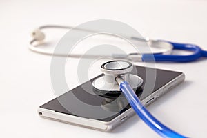 Smartphone being diagnosed by stethoscope - phone repair and check up concept.