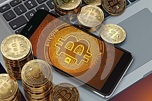 Smartphone with Bitcoin symbol on-screen laying on computer keyboard