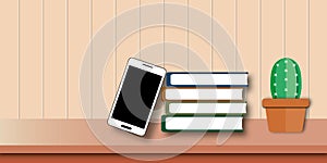 Smartphone with book and cactus on table and wooden background. learn online concept.