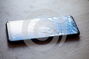 Smartphone with broken touchscreen screen on table desktop