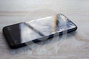 Smartphone with broken touchscreen screen on table desktop