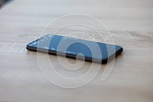 Smartphone with broken touchscreen screen on table desktop