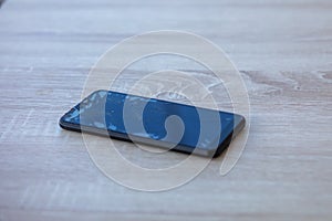 Smartphone with broken touchscreen screen on table desktop