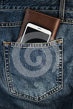 A smartphone and brown leather wallet the back pocket of blue shabby jeans hipster modern life style layout for inserting text