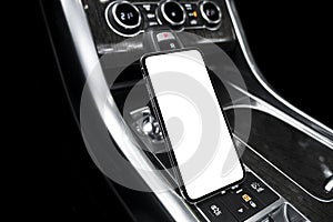 Smartphone in a car use for navigate or GPS. Driving a car with smartphone. Mobile phone with isolated white screen. Blank empty