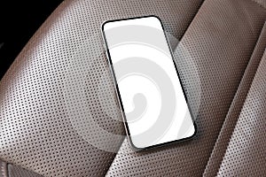 Smartphone in a car use for navigate or GPS. Driving a car with smartphone. Mobile phone with isolated white screen on brown