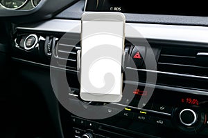 Smartphone in a car use for Navigate or GPS. Driving a car with Smartphone in holder. Mobile phone with isolated white screen.