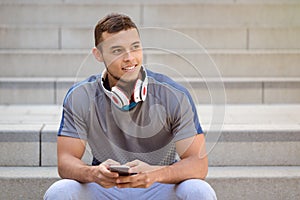 Smartphone cell phone listening to music young latin man looking up listen