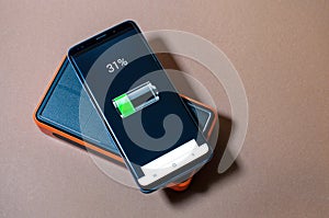Smartphone charging with orange solar power pack, charge level