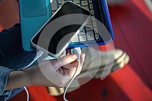 The smartphone is connected to the laptop via USB cable.