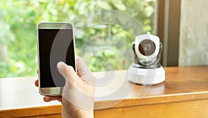 Smartphone connecting with security IP camera on a wooden table