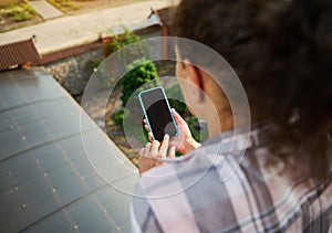 Smartphone with copy ad space on blank screen in the hands of a woman on balcony