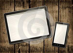 Smartphone and digital tablet PC on a dark wood table