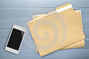 Smartphone and document folders on wooden photo