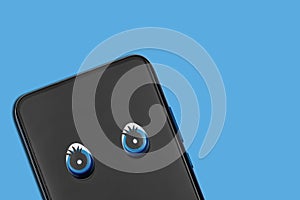Smartphone with eyes isolated on blue background. The concept of Internet espionage
