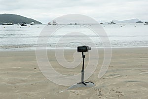 Smartphone in the gimbal filming the beach and boats.
