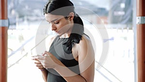 Smartphone girl using app on phone in cafe. Beautiful multicultural young casual female professional on mobile phone.