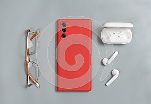 Smartphone, glasses and white wireless earphones