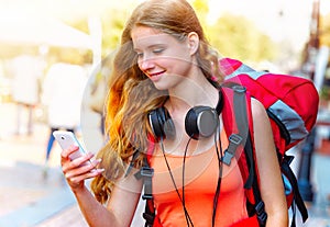 Smartphone with GPS navigator in hands of tourist girl with backpack