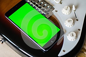 Smartphone with green screen on an Electric Guitars guitar