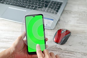 Smartphone with green screen and finger on it