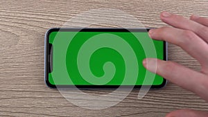 Smartphone with green screen mockup swipe scroll gesture hand close up mobile