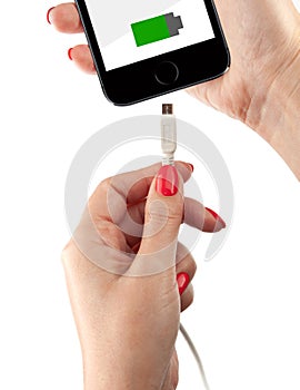 Smartphone in the hand of a woman. Connect the USB cable charger