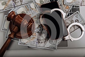 Smartphone with handcuff on a dollar banknotes and judge gavel. Cyber crime and law concept