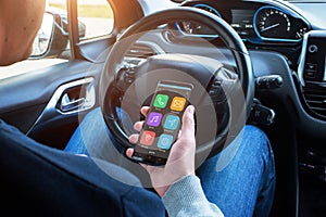 Smartphone in hands of a car driver. The display shows an smart car app with navigation