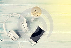 Smartphone, headphones and coffee cup