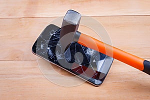 A smartphone hits a hammer and smashes the screen. The concept of electronics repair. Close-up.