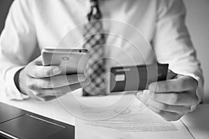 Smartphone and Internet Commerce. Young businessman with a bank credit card in his hands. Payment of goods online.