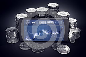 Smartphone with IOTA trading chart on-screen among piles of silver IOTA coins.