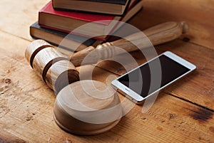 Smartphone, the judge`s gavel on wooden background.