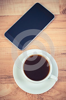 Smartphone, mobile phone with blank screen and cup of coffee