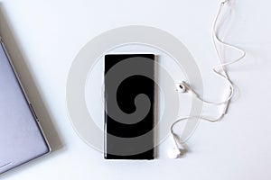 Smartphone mock up and earphones for presentation on white office desk