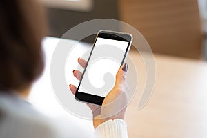 Smartphone mockup image of a woman`s hand holding mobile phone with blank screen