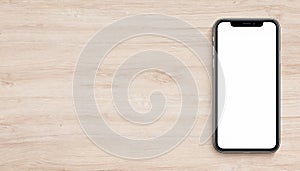 Smartphone mockup similar to iPhone X flat lay top view lying on wooden office desk banner with copy space