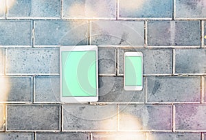 Smartphone and mockup tablet pc against a brick wall
