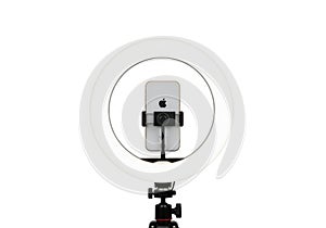 Smartphone mounted on a ring light and tripod isolated on white background