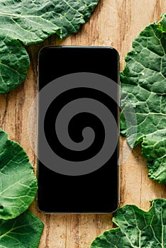 Smartphone next to green leafy vegetables