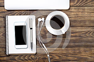 Smartphone with notebook and cup of strong coffee