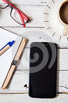Smartphone with notebook and cupon wooden table photo