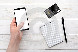 Smartphone, notebook, pen and credit card on a white table