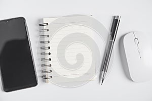 Smartphone, notepad, pen, computer mouse on white background